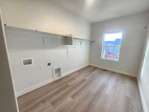 Laundry room with light wood-style flooring, electric dryer hookup, and hookup for a washing machine