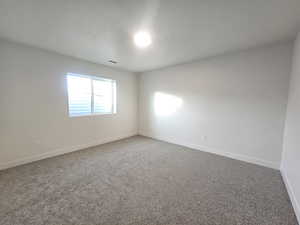 Empty room featuring carpet floors and baseboards