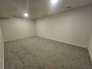 Spare room featuring baseboards and carpet floors