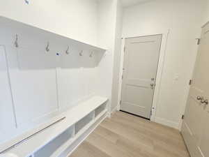 Mudroom with light wood-style flooring and baseboards