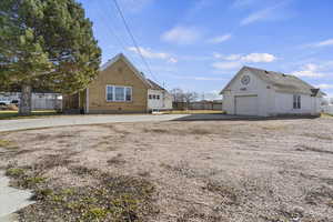 View of home's exterior with an outdoor structure, brick siding, and driveway