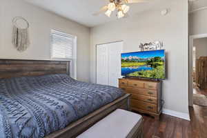 Bedroom with dark wood-style floors, a closet, and ceiling fan