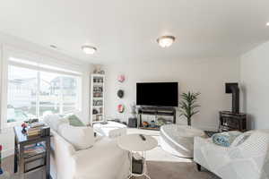 Carpeted living room with a wood stove and baseboards
