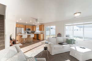 Living room featuring light wood-type flooring, recessed lighting, and a ceiling fan