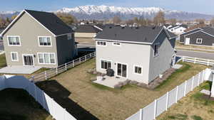 Back of house featuring a patio area, a mountain view, a residential view, stucco siding, and a fenced backyard