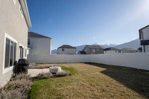 Fenced backyard with a mountain view, a residential view, and a patio area