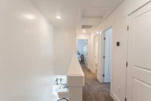 Corridor with dark carpet and recessed lighting