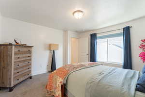 Carpeted bedroom featuring baseboards
