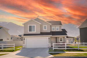 Traditional-style house featuring covered porch, driveway, an attached garage, roof with shingles, and stucco siding