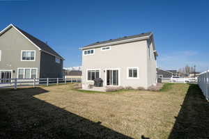 Rear view of house with a patio, a fenced backyard, and stucco siding