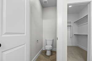 Bathroom featuring a spacious closet and toilet