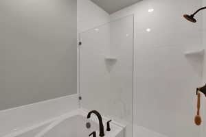 Bathroom featuring a garden tub and a tile shower