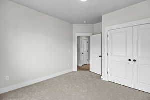 Unfurnished bedroom featuring carpet flooring and a closet