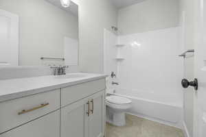 Bathroom featuring vanity, bathtub / shower combination, and light tile patterned floors