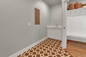 Mudroom with baseboards and electric panel