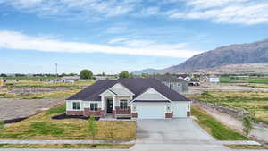 Craftsman house with brick siding, concrete driveway, an attached garage, board and batten siding, and a front lawn