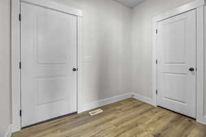 Doorway with wood finished floors and baseboards