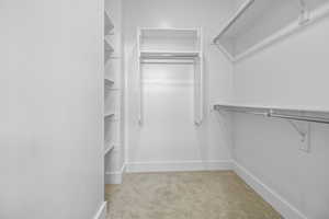 Walk in closet featuring light carpet