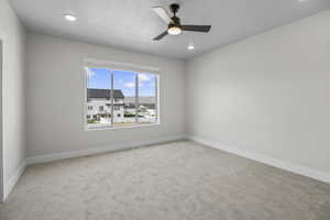 Spare room with carpet floors, a ceiling fan, and recessed lighting