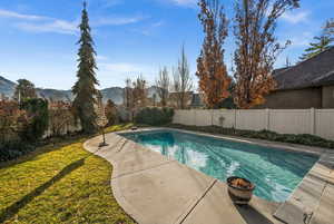 View of swimming pool featuring a fenced backyard, patio surround, and a mountain view