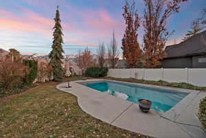View of swimming pool featuring a fenced backyard and patio surround