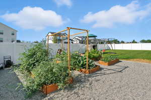 Fenced backyard featuring a vegetable garden