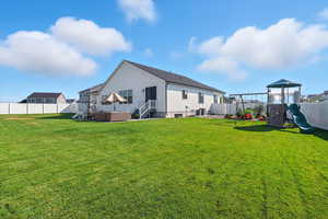 Back of house featuring a playground, a fenced backyard, and a patio area