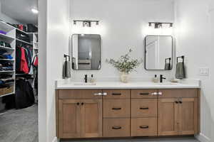 Primary Bathroom featuring double vanity and a walk in closet