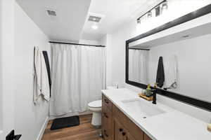 Basement Full bath with vanity and dark wood-style flooring