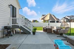 Fenced backyard featuring a patio area, a grill, outdoor furniture, and a residential view