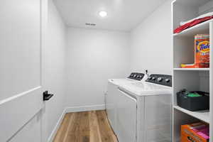 Basement Laundry area featuring light wood-style flooring and washing machine and clothes dryer