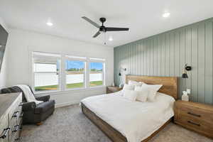 Primary Bedroom with a ceiling fan, carpet floors, recessed lighting, and wood walls