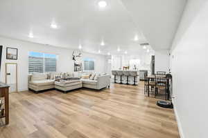 Basement Living room with light wood finished floors and recessed lighting