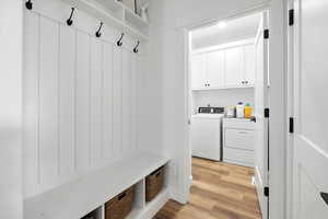 Upstairs Mudroom featuring light wood-style flooring and separate washer and dryer