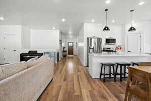 Living area with light wood-style flooring, recessed lighting, and a fireplace