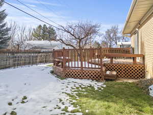 Snowy yard featuring a wooden deck