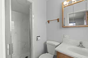 Bathroom featuring vanity and a marble finish shower