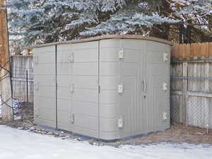 Snow covered structure with a storage shed