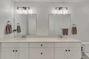 Full bath featuring double vanity and toilet