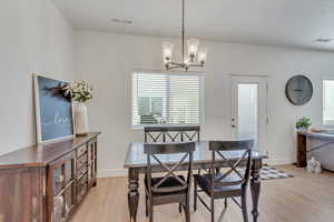 Dining area featuring light wood-type flooring and suspended lighting