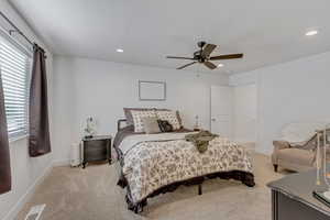 Bedroom with light carpet, a ceiling fan, and recessed lighting