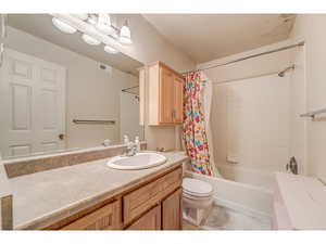 Bathroom featuring vanity and shower / bath combination with curtain