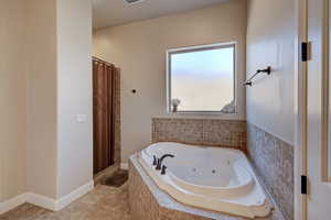Full bathroom with a stall shower, a jetted tub, and light tile patterned flooring