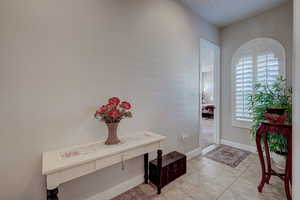 Foyer with baseboards and light tile patterned floors
