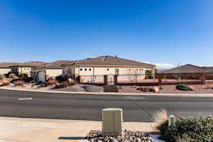 View of front of property featuring a fenced front yard, a tile roof, stucco siding, an attached garage, and a gate