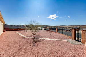 Fenced backyard featuring a gate