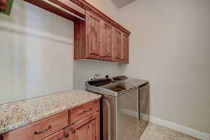 Laundry area featuring cabinet space and separate washer and dryer