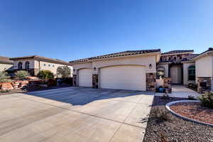 Mediterranean / spanish-style house featuring stone siding, stucco siding, driveway, and a garage