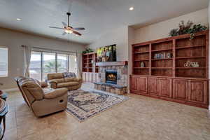 Living room with a ceiling fan, light tile patterned flooring, a fireplace, recessed lighting, and a textured ceiling
