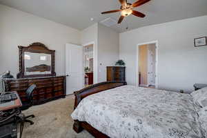 Bedroom featuring light colored carpet, a ceiling fan, and a desk